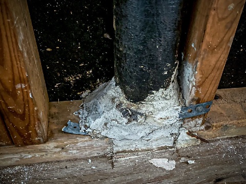 White fireproofing on pipe between beams